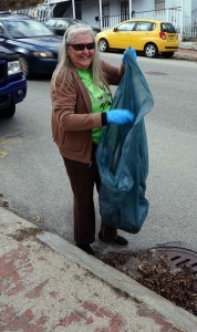 Jacqui Deveneau stuffs litter in the city provided trash bag on Parkside Clean-up Day.