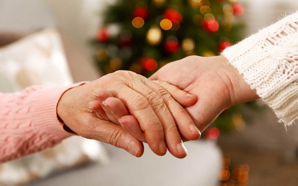 West End News - The Dearest Gift - Hands holding before a decorated tree - Adobe Stock photo