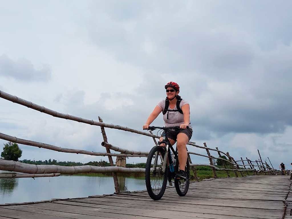 Mary Powers on rickety bridge during bicycle excursion outside of Hoi An