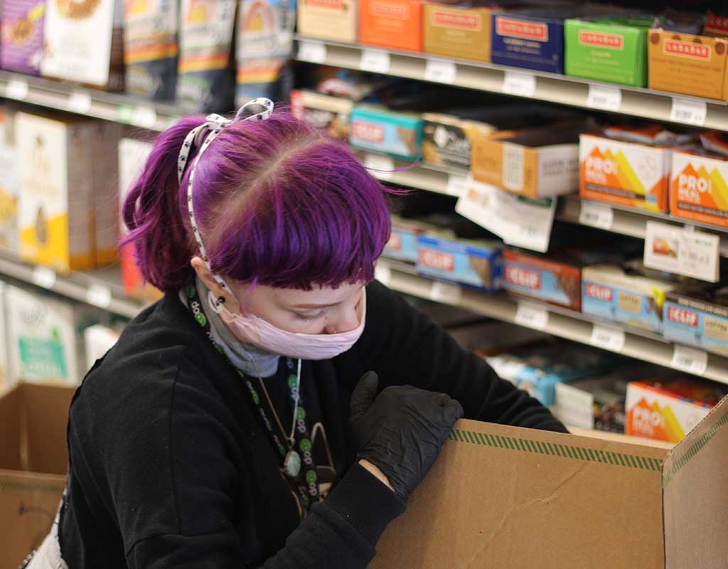 West End News - Local Farms innovate - Haley unpacks a shipment at the Portland Food Co-op