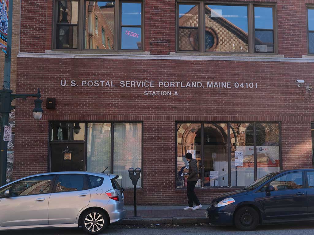 Postal customer with packages in front of USPS Post Office Station A