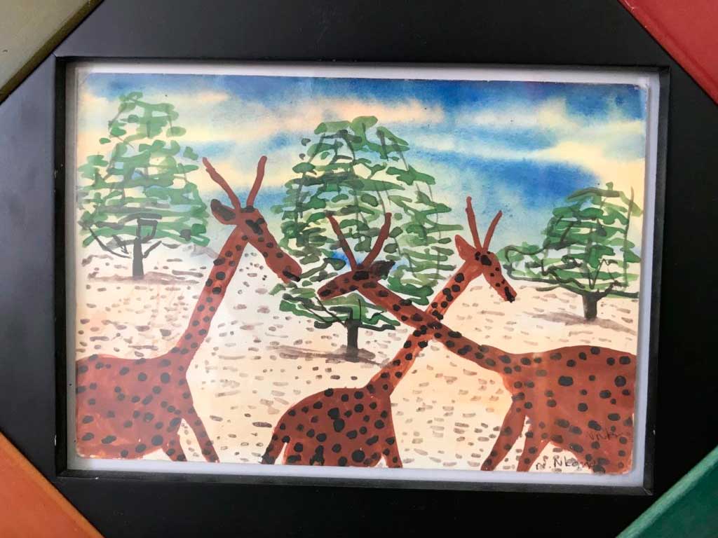 Nancy's art from her travels, a painting of giraffes from Zimbabwe