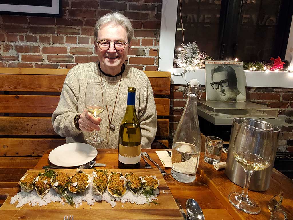 Layne Witherell sitting before the Maine Oyster Company's Oysters Rockefeller - eight large Damariscotta oysters - part of a prix fixe menu
