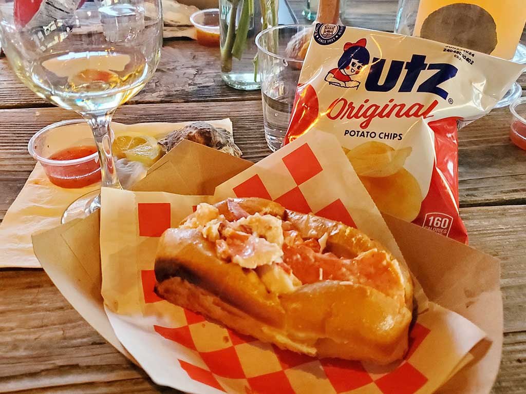 Lobster roll with chips and wine at Maine Oyster Company's Basecamp