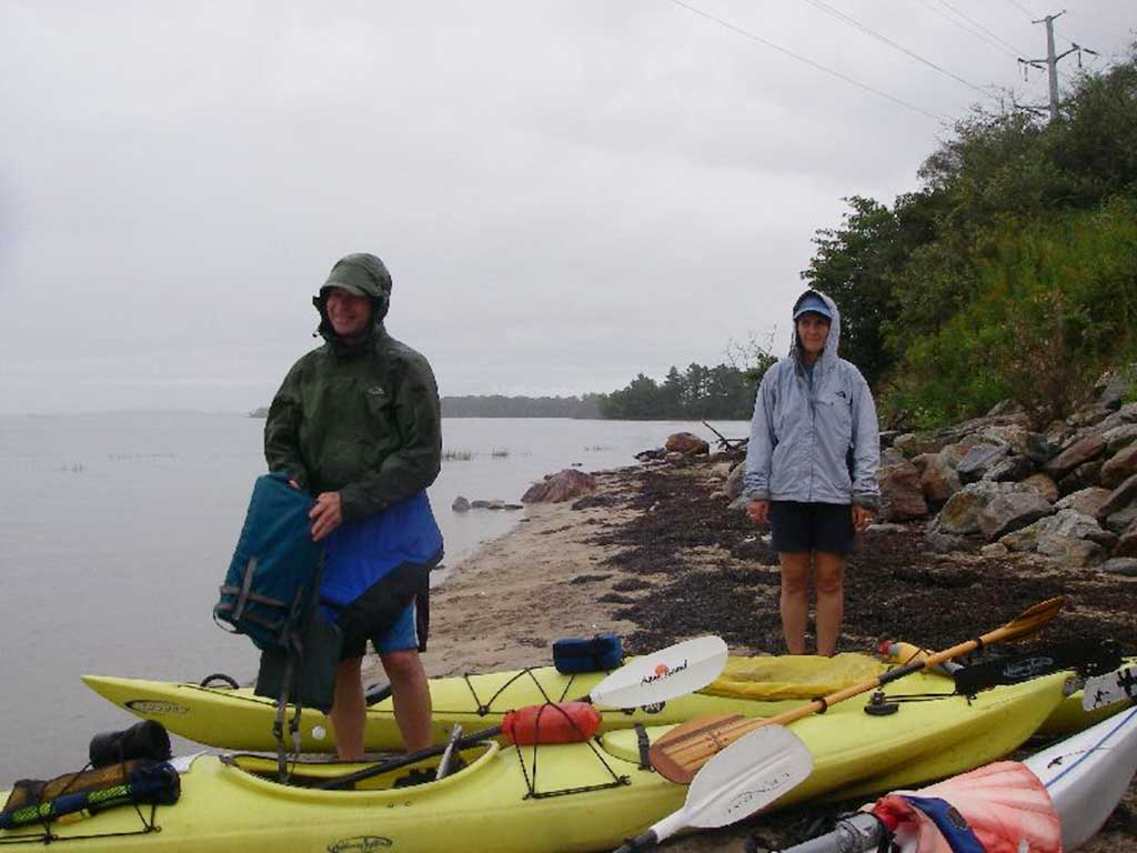 West End News - Packing up kayaks in light rain at Sandy Point Beach