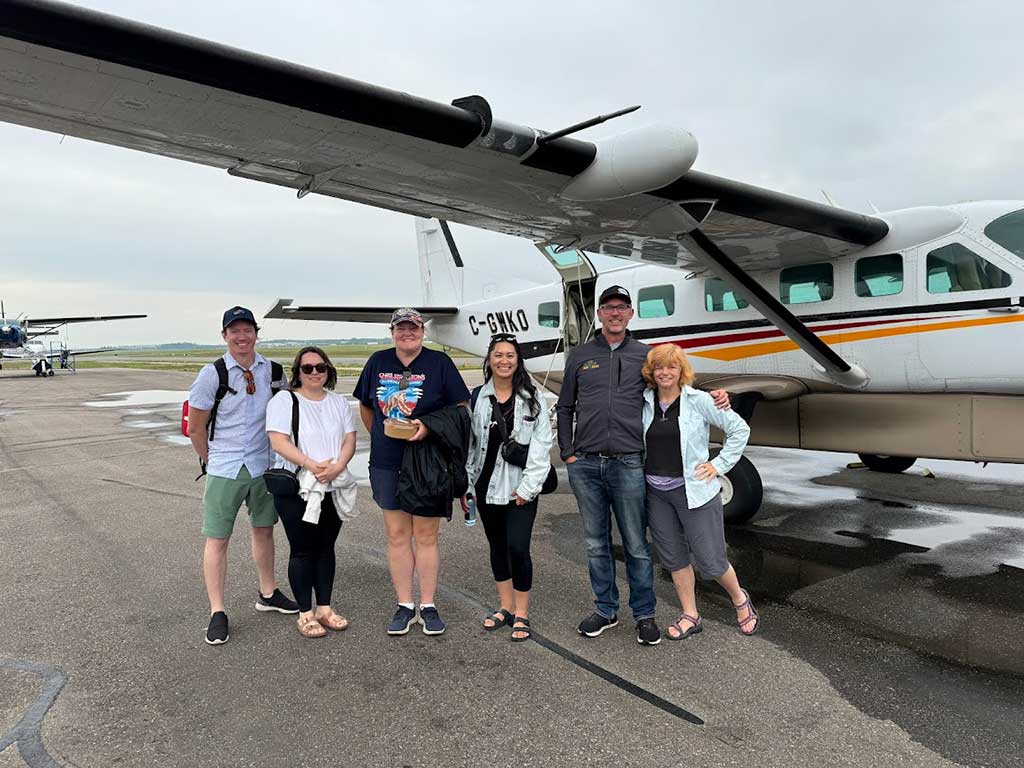 Group with plane that would take them to the lodge