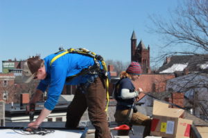 West End News - ReVision Energy crew installs solar power on the roof of West End building