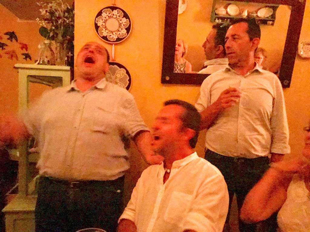 Restaurant owner Artur belts out a traditional song alongside Paolo at Fado dinner